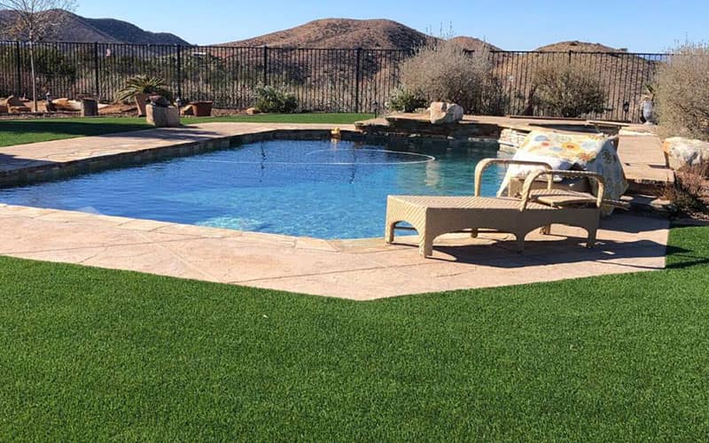 Artificial turf laid around a patio and pool deck by HaloTurf